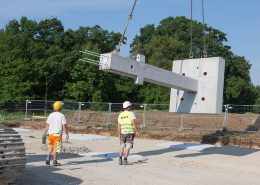 Die schweren Bauteile werden mit Sattelzügen angeliefert und müssen mit einem Kran abgeladen und an der richtigen Position auf der Baustelle platziert werden.